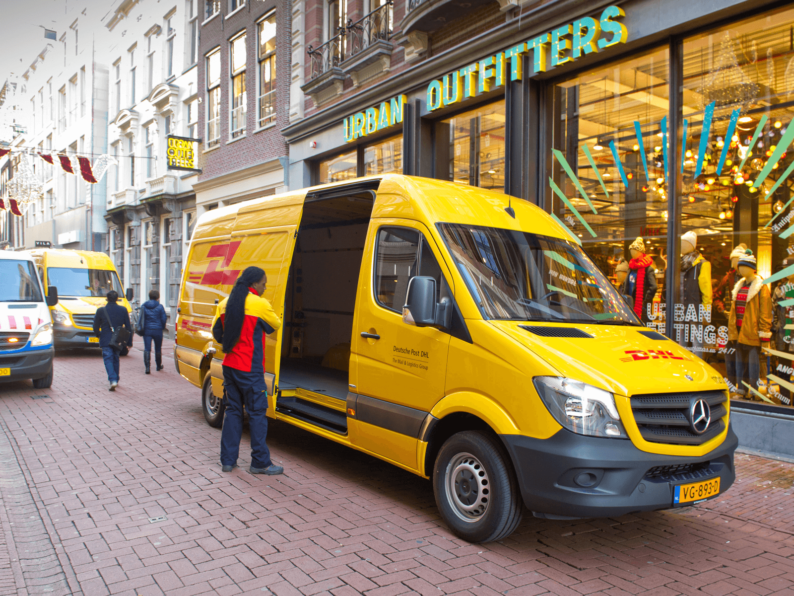 DHL deliverer near an electric van